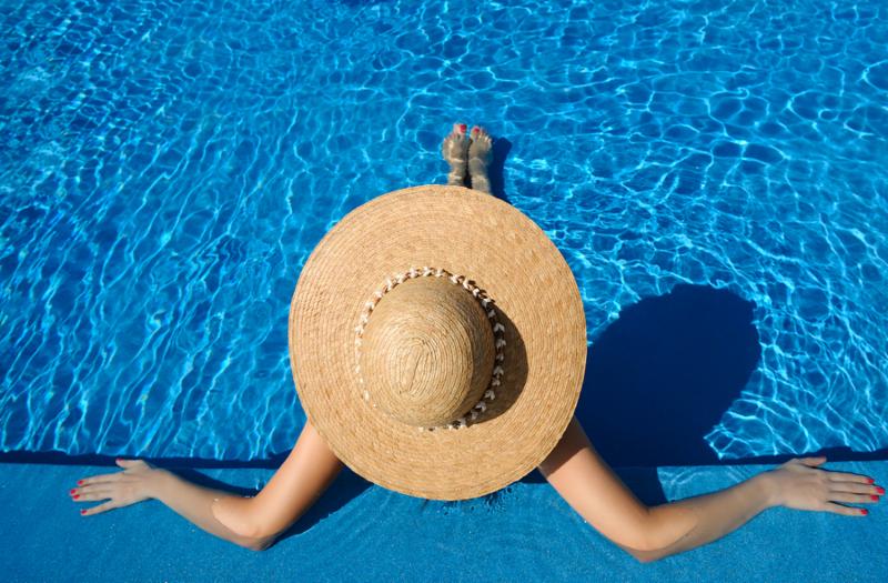 image of a lady in a hat by the pool
